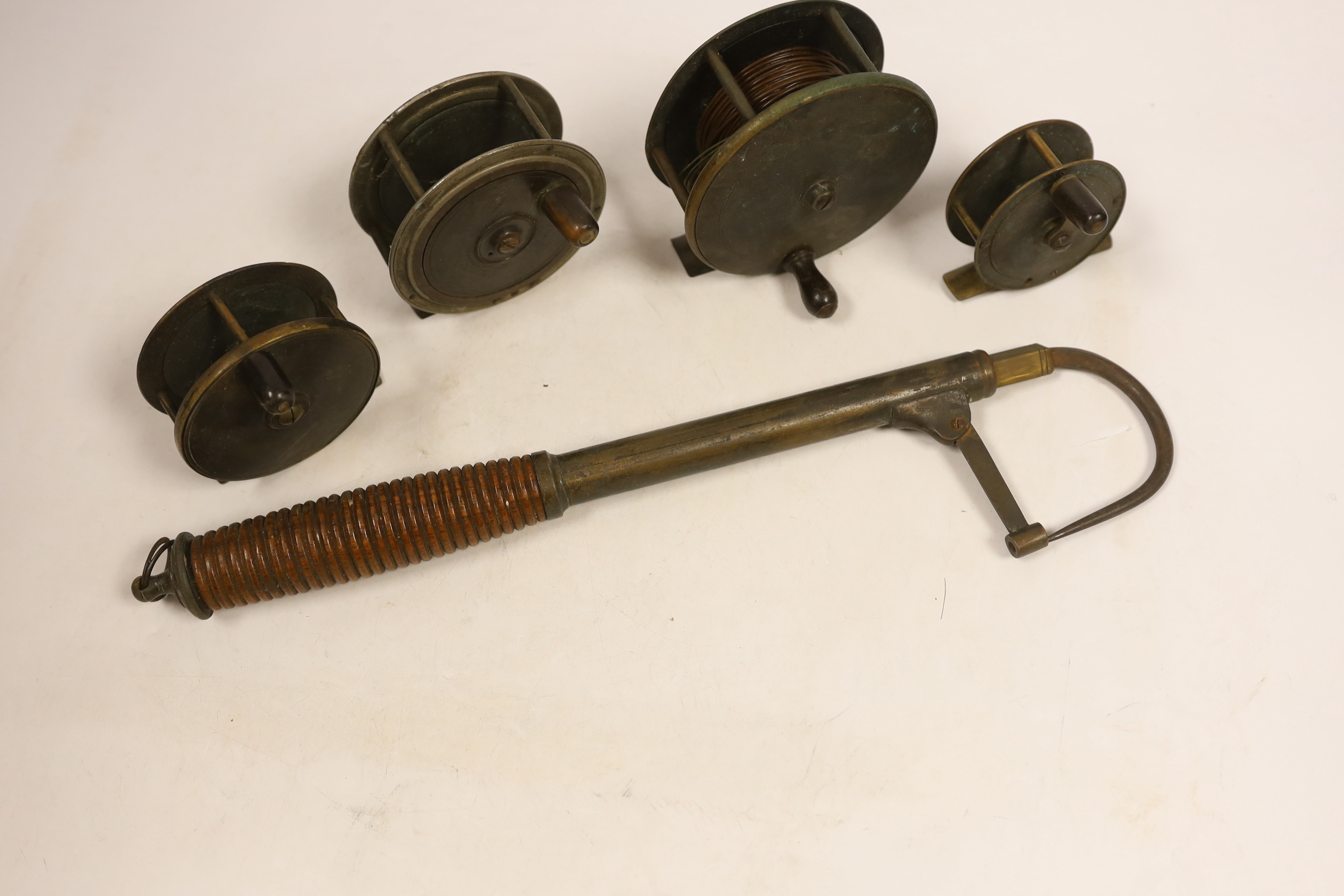 Four various sized fishing reels and a hook